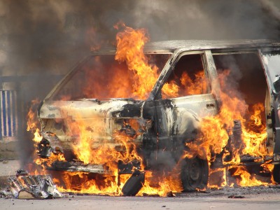 A car engulfed in flames with intense fire and smoke.