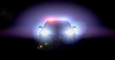 A silhouette of a police car with flashing lights against a dark background.